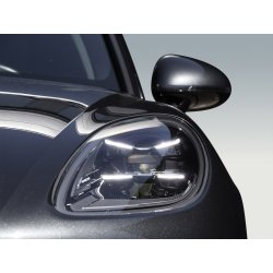 Detalle del faro delantero de un vehículo premium negro para retoque profesional de coche.